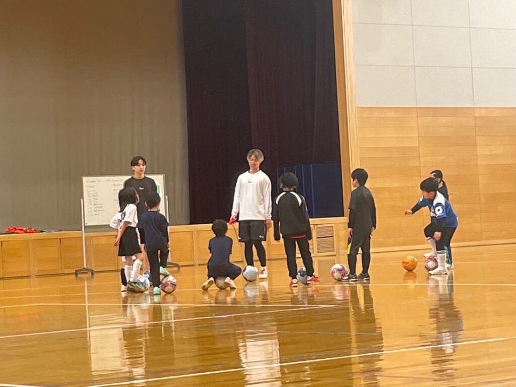 子どもたちにフットサルを教えている